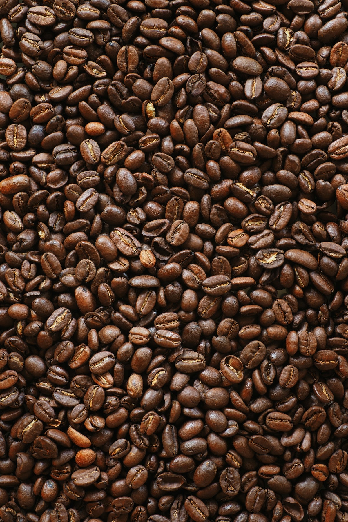 brown coffee beans on black surface