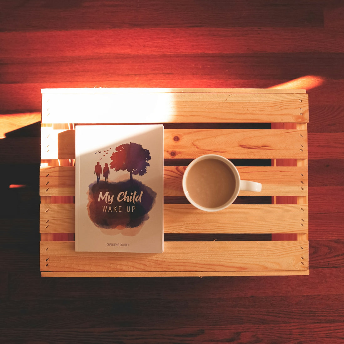 a cup of coffee and a book on a wooden table