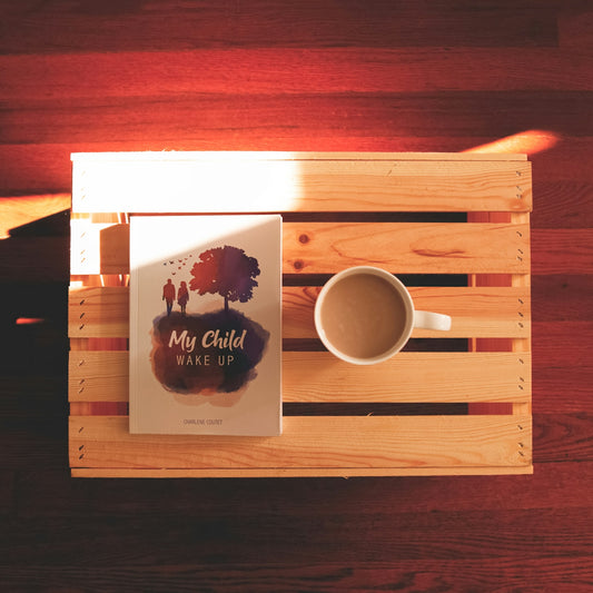 a cup of coffee and a book on a wooden table