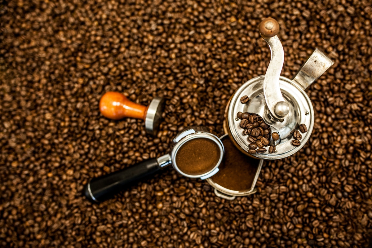 an overhead view of a coffee grinder and a cup of coffee