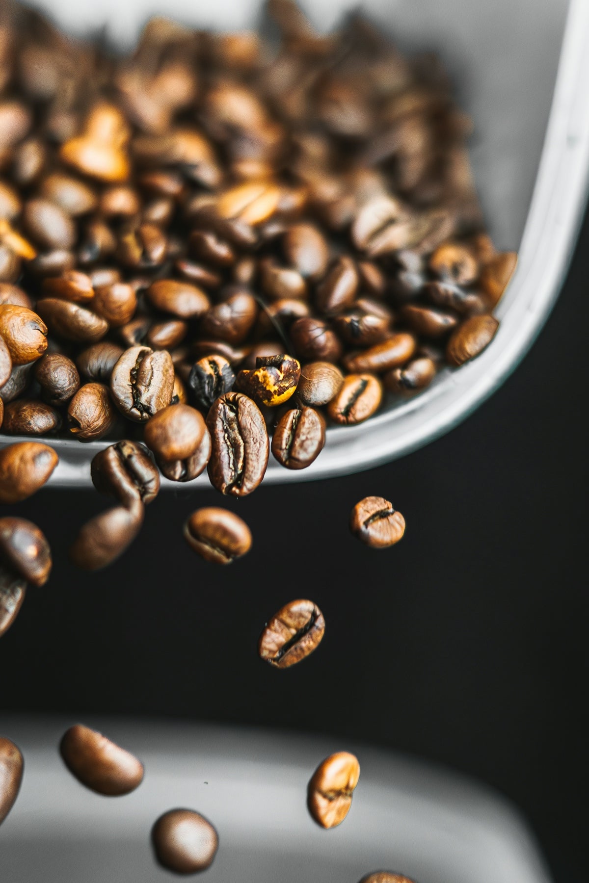 a spoon full of coffee beans on top of a table