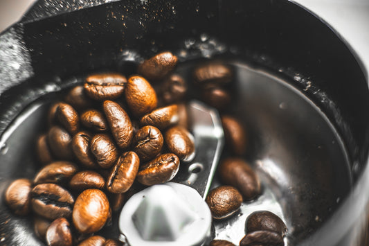 a blender filled with nuts and a spoon