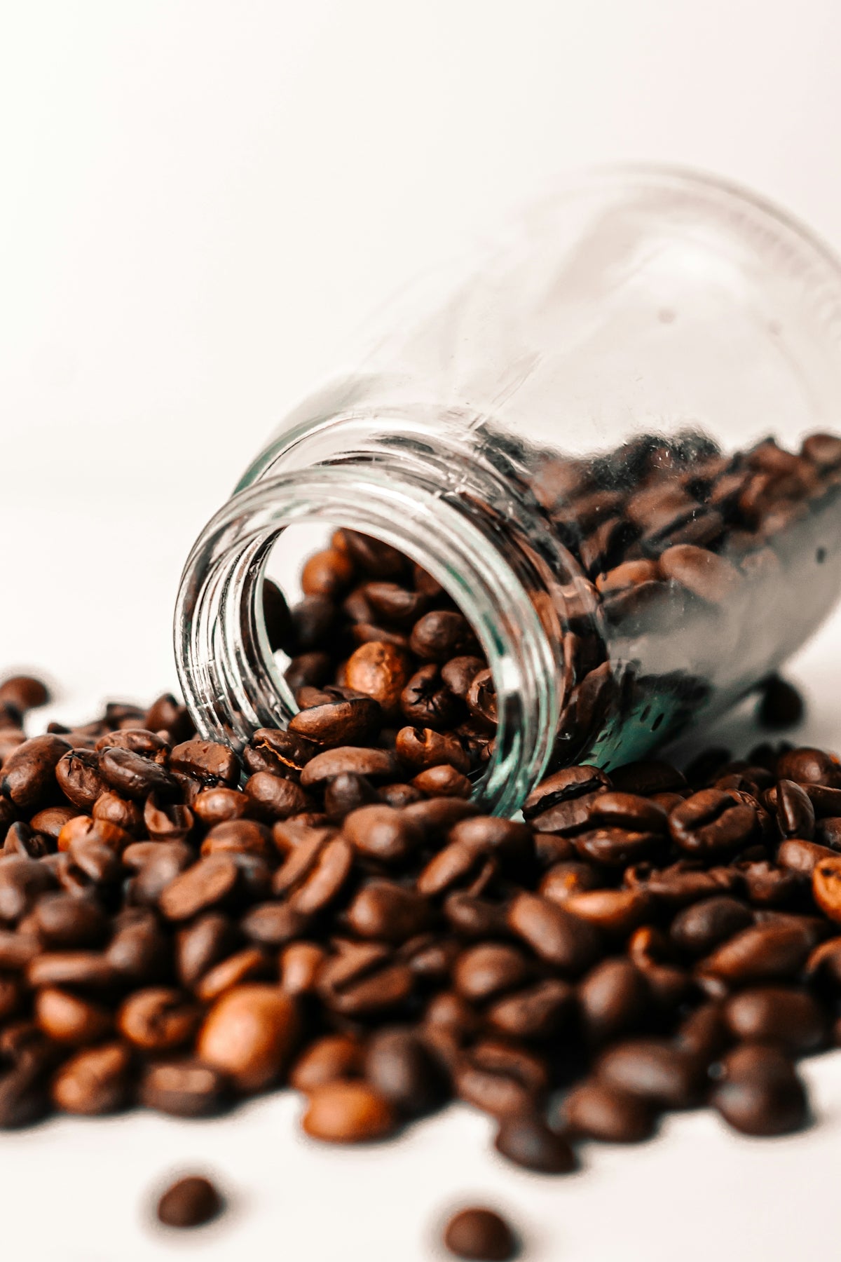 a glass jar filled with coffee beans on top of a table