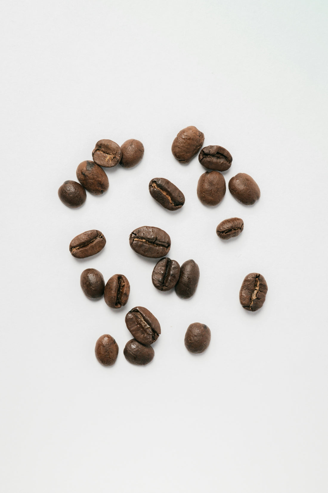 A pile of coffee beans sitting on top of a white table